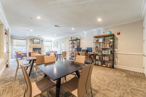Game room and library with a selection of books, a computer center, and board games at Encore at Buckingham apartments in Richardson, TX